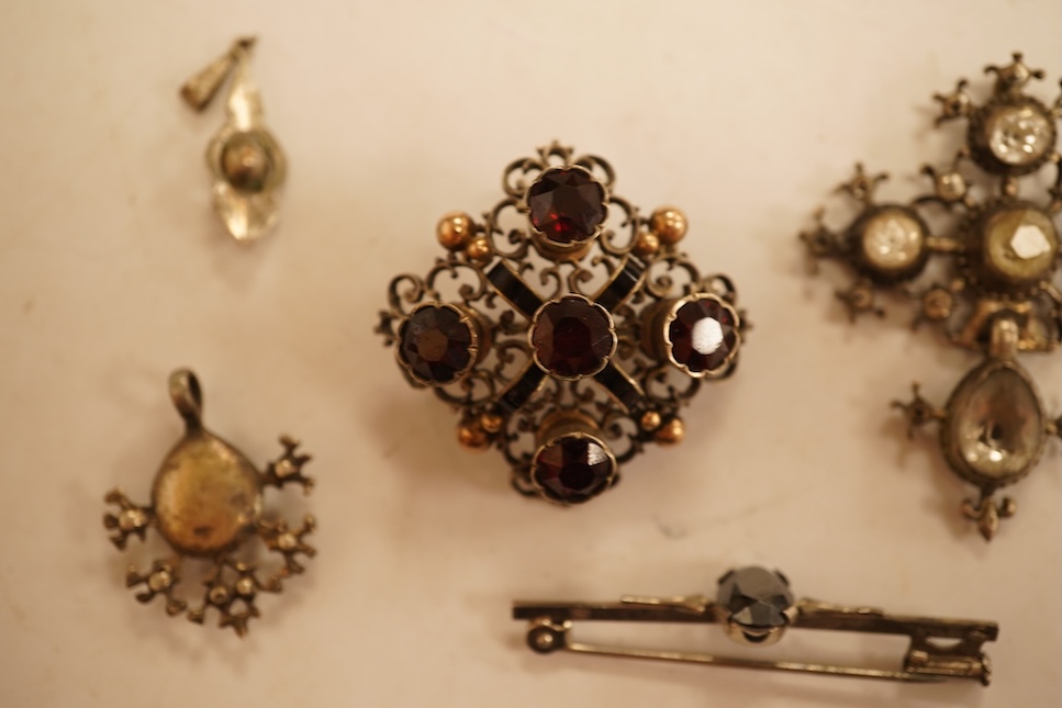 A late 19th/early 20th century Viennese pierced white metal, enamel and garnet cluster set brooch, 34mm, together with four other items of paste set jewellery.